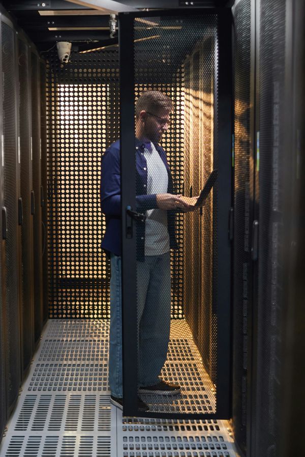 Technicien Clariteam en intervention dans une allée de baies de datacenter